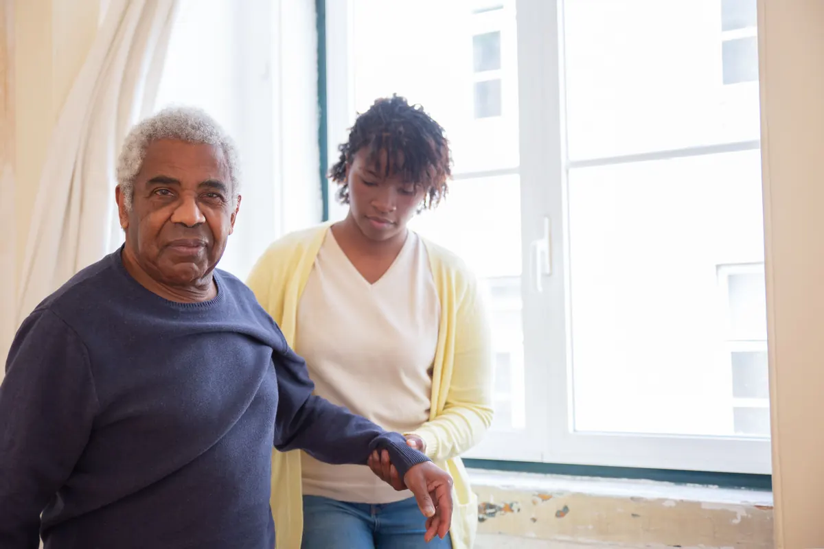 Elderly man receiving care near a bright window