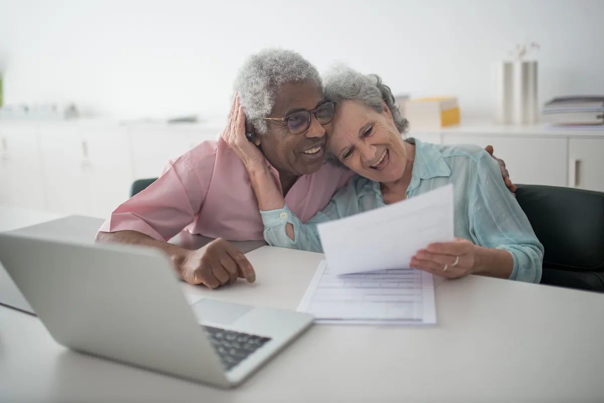 Senior couple reviewing care paperwork with documents at a desk